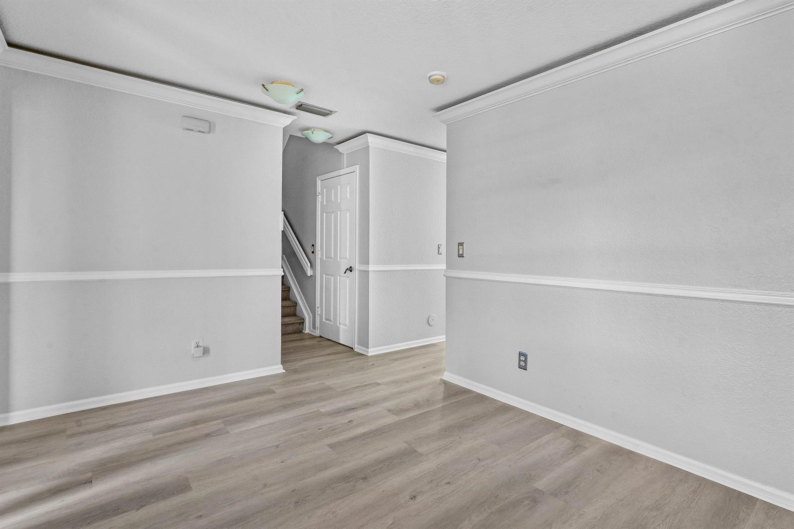 An empty room with light gray walls, white trim, and wood-look flooring — 3260 Commodore Court, West Palm Beach FL 33411, WEST PALM BEACH, FL