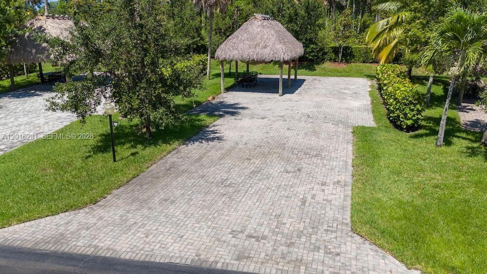 An aerial view shows two tiki huts situated on a paved brick patio area — 147 S Cortez Dr, Margate FL 33068, MARGATE, FL