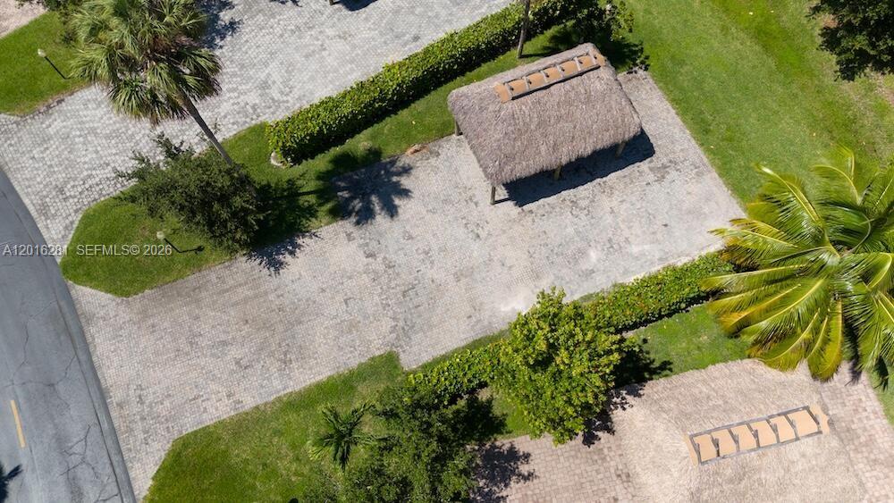 An aerial view shows two thatched-roof structures situated on a paved lot with landscaping — 147 S Cortez Dr, Margate FL 33068, MARGATE, FL