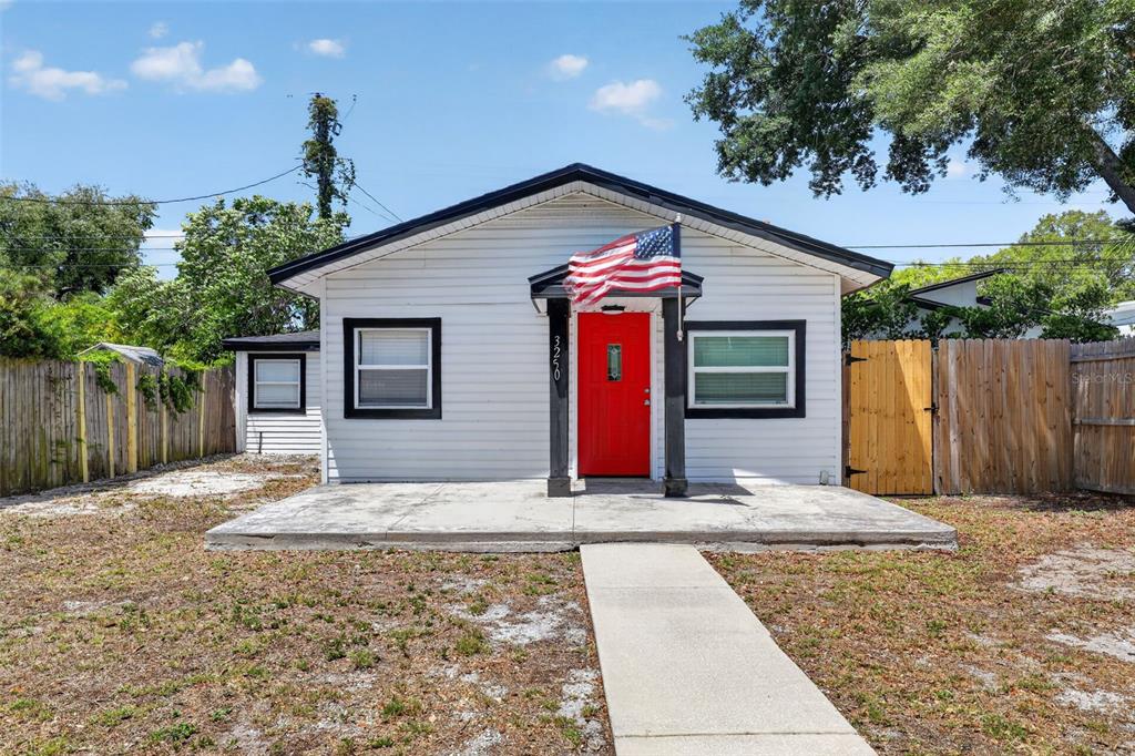 A single-story white house with a red front door and a concrete porch — 3250 PRESCOTT STREET N, ST PETERSBURG, FL