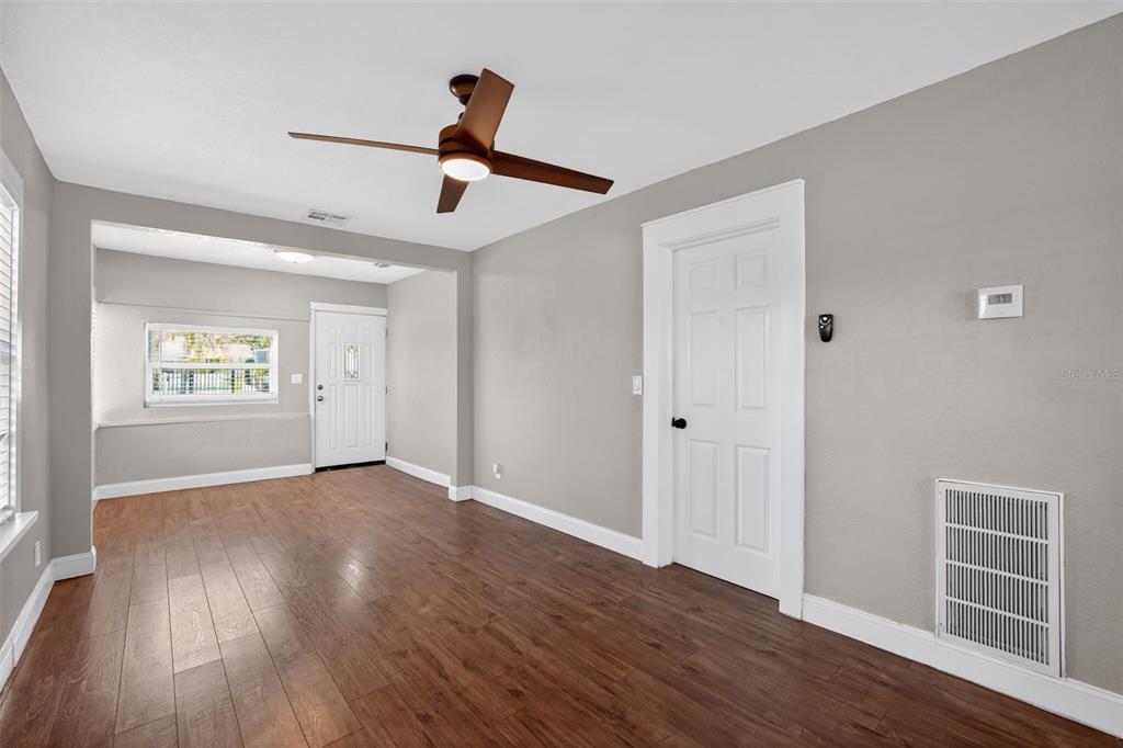 A room with wood-look flooring, gray walls, a ceiling fan, and a white door — 3250 PRESCOTT STREET N, ST PETERSBURG, FL