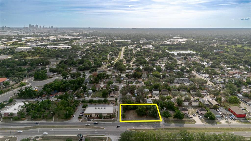 An aerial view shows a vacant, rectangular lot highlighted in yellow along a busy road — 3206 N 50TH STREET, TAMPA, FL