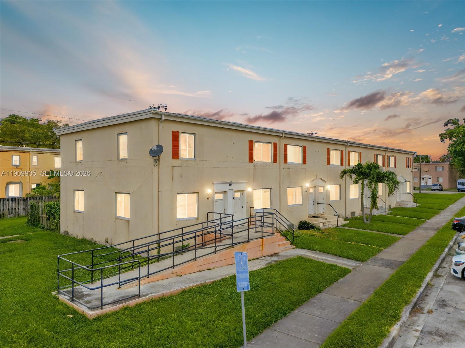 An exterior view of a two-story apartment building featuring a wheelchair ramp and lawn — 427 NW 84th Ter # 427, Miami FL 33150, MIAMI, FL