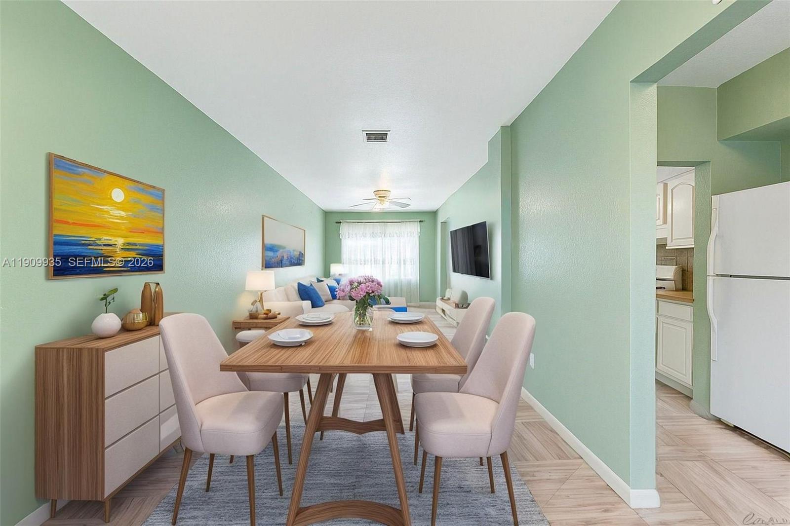 A dining area with a wooden table and chairs opens into a living room — 427 NW 84th Ter # 427, Miami FL 33150, MIAMI, FL