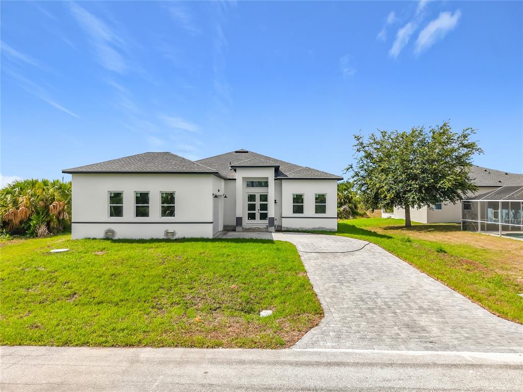 A modern, single-story white house with a gray roof and a paved driveway — 14382 FORT WORTH CIRCLE, PORT CHARLOTTE, FL