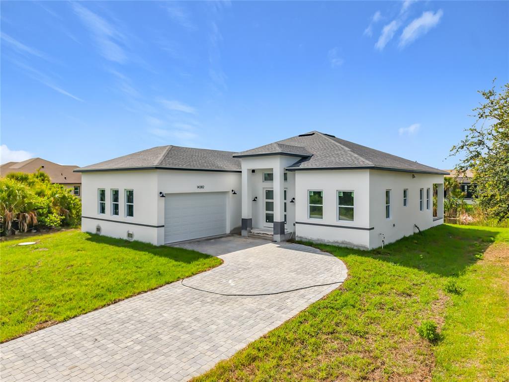 An aerial view of a single-story white house with a gray roof and paved driveway — 14382 FORT WORTH CIRCLE, PORT CHARLOTTE, FL