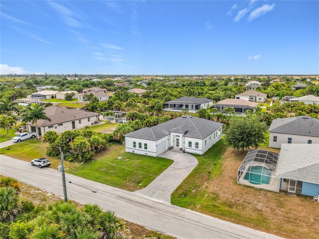 A modern white house exterior features a paved driveway, a garage, and a front entrance — 14382 FORT WORTH CIRCLE, PORT CHARLOTTE, FL
