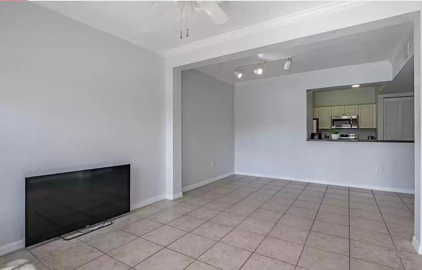 An open-concept living area features light gray walls, tiled flooring, and a pass-through kitchen window — 2308 57th Circle # 2308, Vero Beach FL 32966, VERO BEACH, FL
