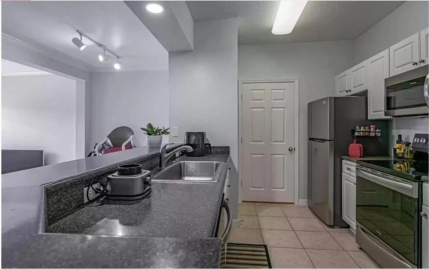 A kitchen features dark granite countertops, stainless steel appliances, and white cabinets — 2308 57th Circle # 2308, Vero Beach FL 32966, VERO BEACH, FL