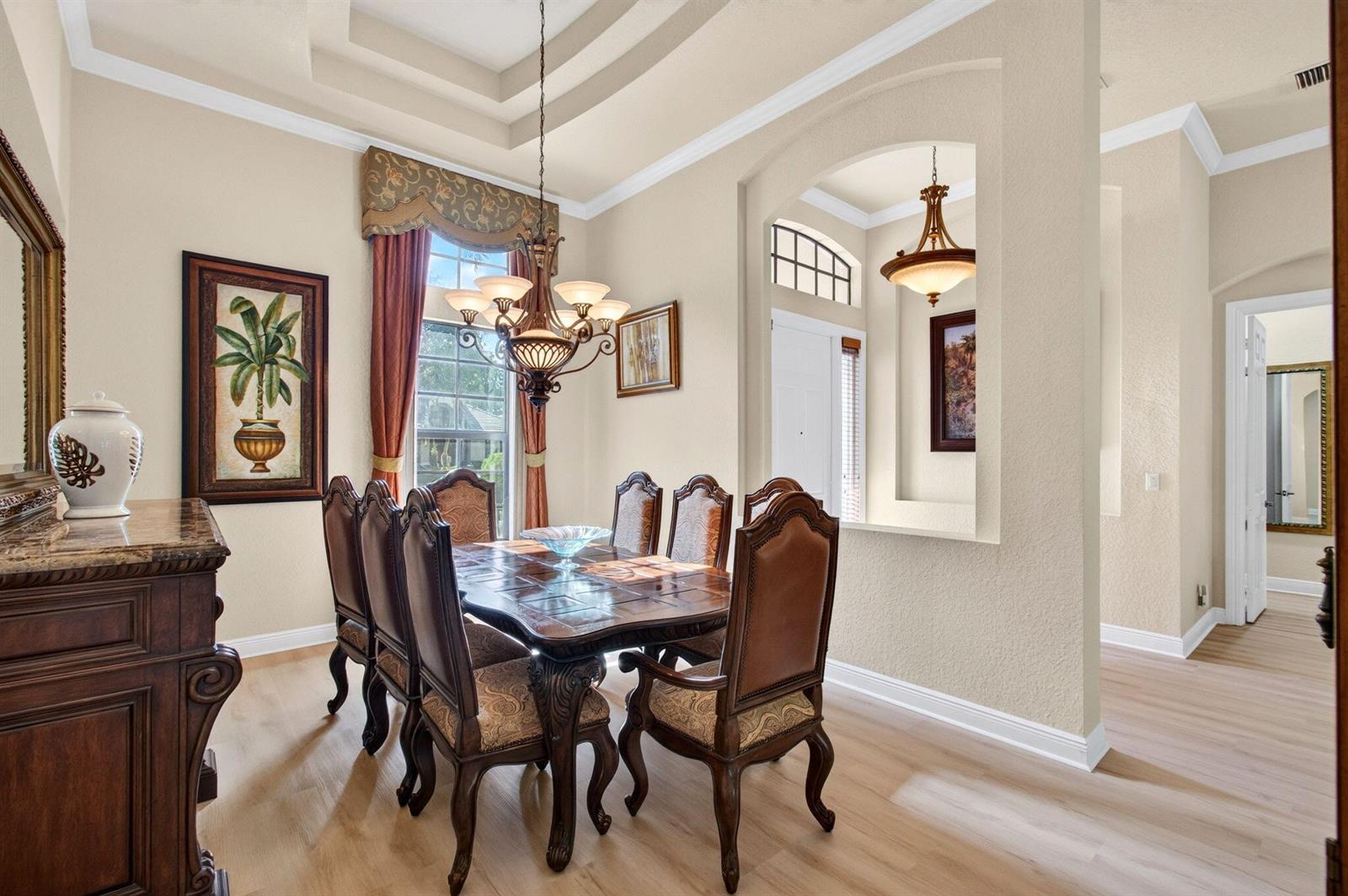 A formal dining room features a dark wood table, upholstered chairs, and a tray ceiling — 16211 Rosecroft Terrace, Delray Beach FL 33446, DELRAY BEACH, FL