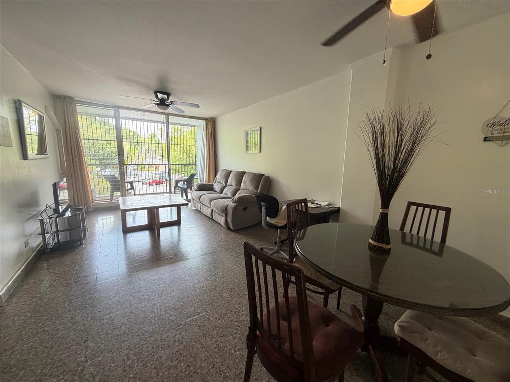 A living and dining area with tile floors, a sofa, and a balcony with security bars — Apt 207 BORINQUEN TOWERS UNIT 207, SAN JUAN, PR