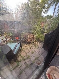 A paved patio area features a chair, potted plants, and a partial view of a fence — 162 SE 33rd Ter, Homestead FL 33033, HOMESTEAD, FL