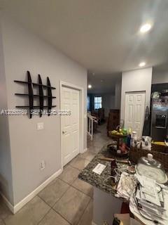 A kitchen counter with clutter overlooks a hallway featuring a black wall shelf and white doors — 162 SE 33rd Ter, Homestead FL 33033, HOMESTEAD, FL