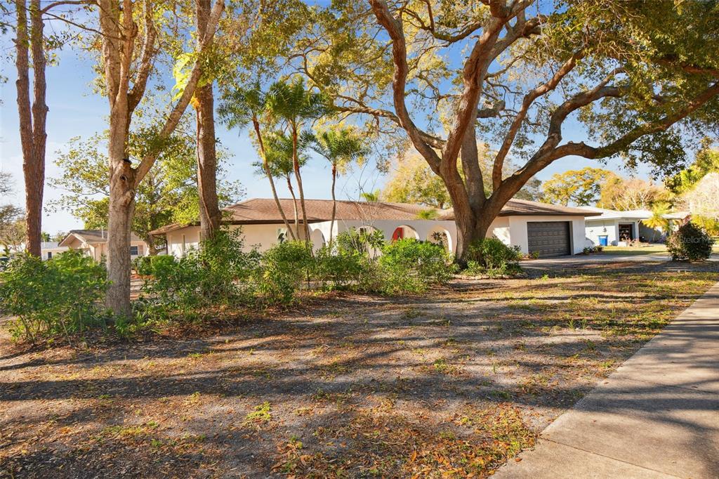 A single-story house with a brown roof, arched entryway, and a dark garage door — 570 CASLER AVENUE, CLEARWATER, FL