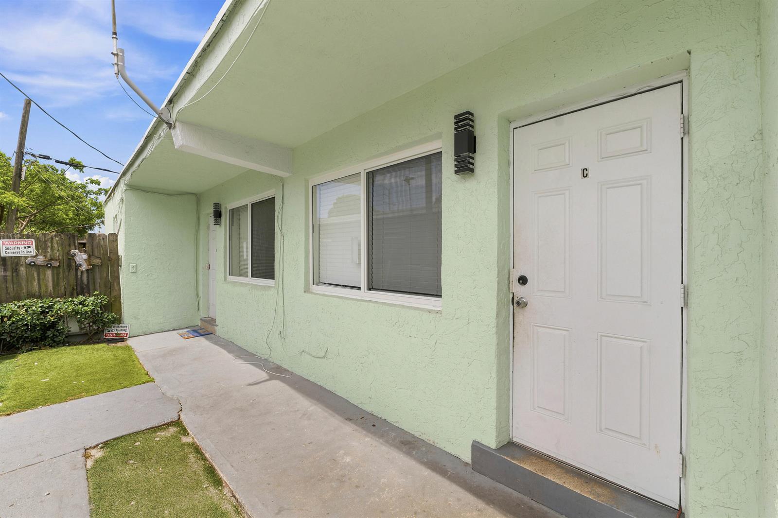 A pale green exterior wall features a white door labeled C and two windows — 166 SW 3rd Street # d, Deerfield Beach FL 33441, DEERFIELD BEACH, FL