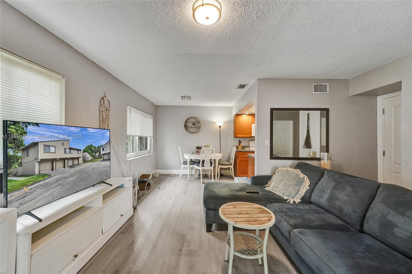 A living room features a grey sectional sofa, a white media console, and a dining area — 2218 NW 59th Way # B, Lauderhill FL 33313, LAUDERHILL, FL