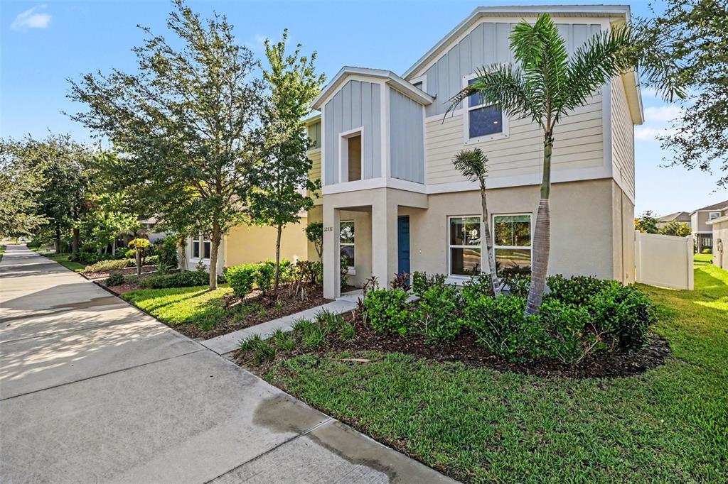 A two-story house with light-colored siding, a palm tree, and a concrete walkway — 12531 TRIPLE CREEK BOULEVARD, RIVERVIEW, FL