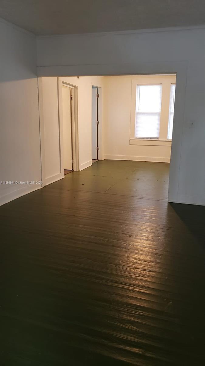 An interior view shows a room with dark wood flooring leading to an adjacent space — 1517 Logan # 0, Jacksonville FL 32209, JACKSONVILLE, FL