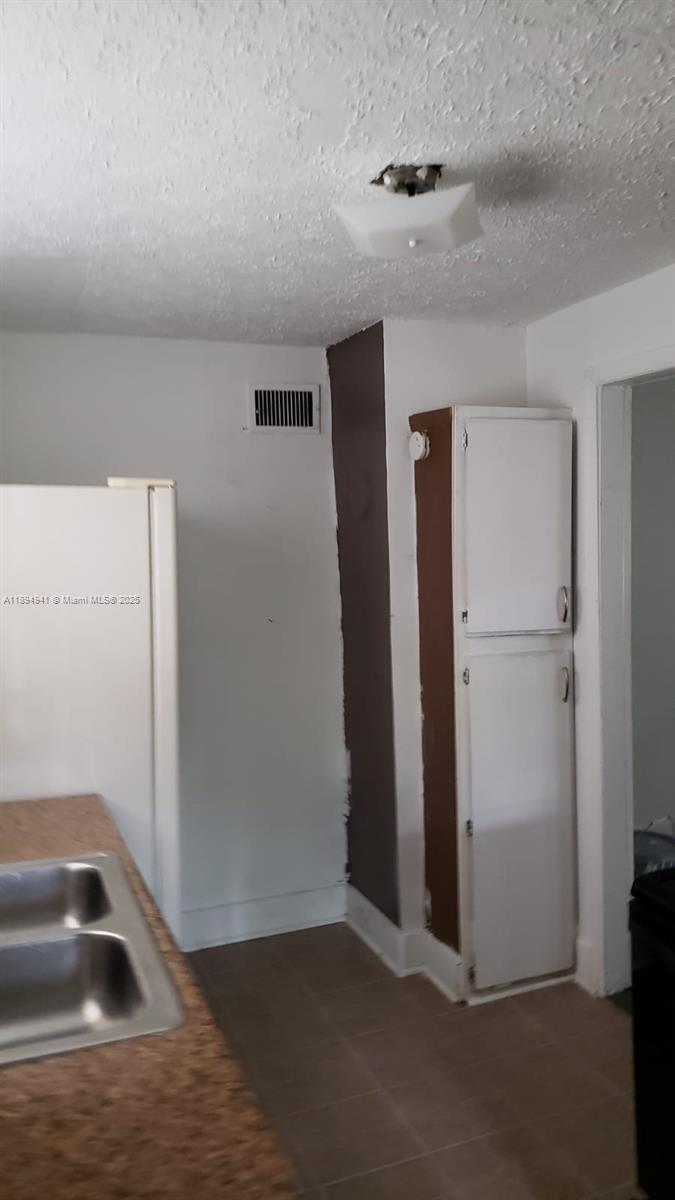 A kitchen features a white refrigerator, a tall pantry cabinet, and a stainless steel sink — 1517 Logan # 0, Jacksonville FL 32209, JACKSONVILLE, FL