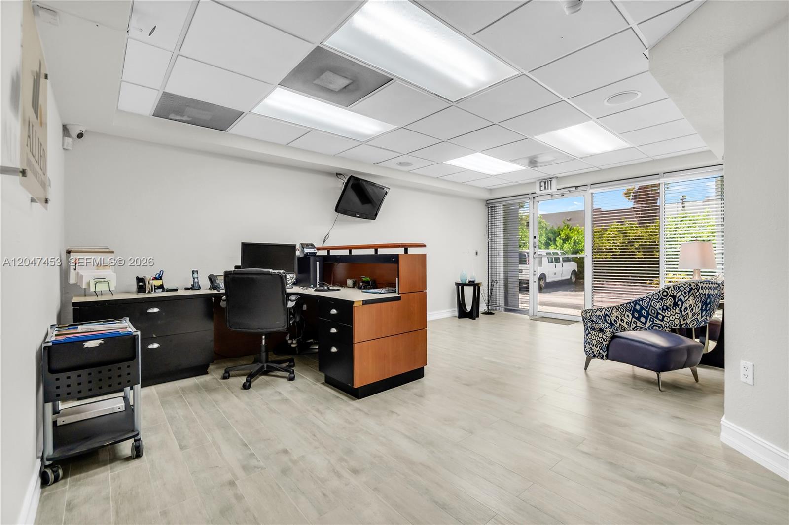 An office space features a desk, a rolling cart, a patterned armchair, and glass doors — 16155 SW 117th Ave # B17, Miami FL 33177, MIAMI, FL