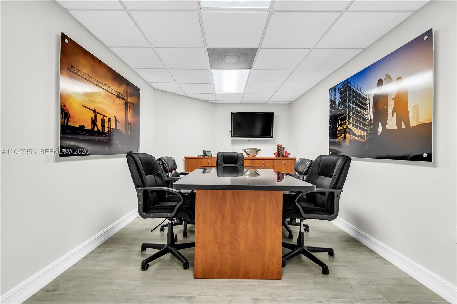 A conference room features a dark table, black chairs, and large construction-themed wall art — 16155 SW 117th Ave # B17, Miami FL 33177, MIAMI, FL