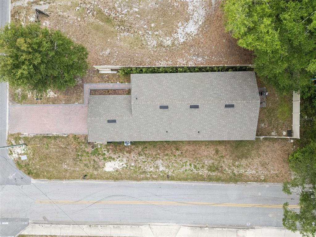 An aerial view shows a house with a gray shingled roof and a paved driveway — 520 S KENTUCKY AVENUE, DELAND, FL