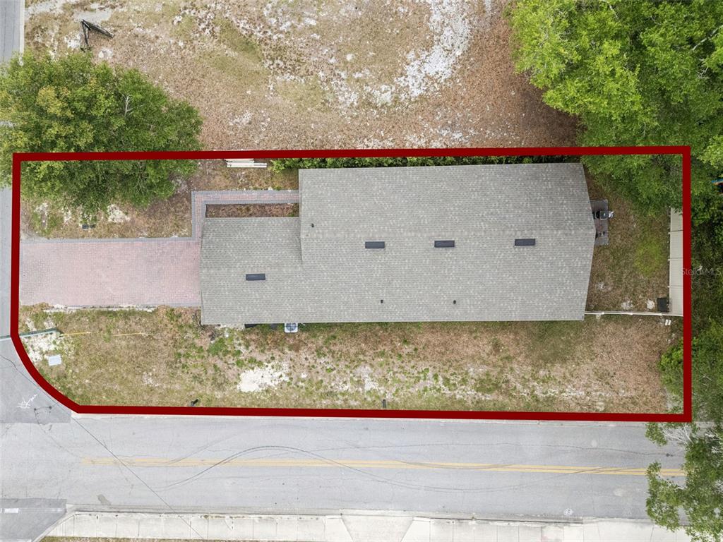 An aerial view shows a house with a gray roof and a brick driveway — 520 S KENTUCKY AVENUE, DELAND, FL
