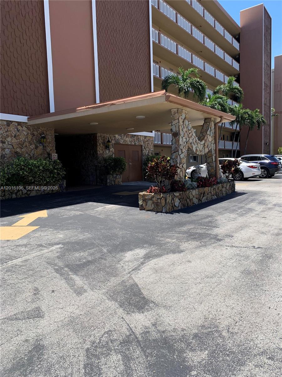 The exterior of a multi-story building features a stone-clad porte-cochère and a paved driveway — 501 NE 14th Ave # 601, Hallandale Beach FL 33009, HALLANDALE BEACH, FL