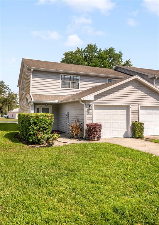 A two-story townhouse with light gray siding, two garage doors, and a front lawn — 321 ORANGE BLOSSOM DRIVE, WINTER HAVEN, FL