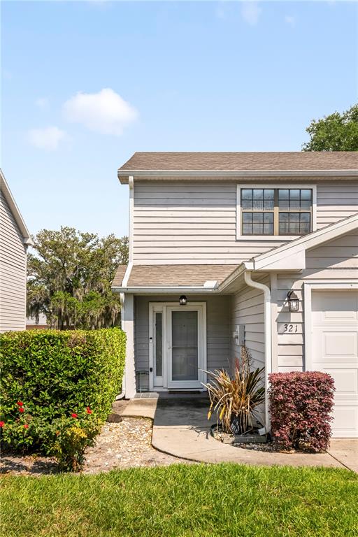 A two-story house with light gray siding, a two-car garage, and a manicured front lawn — 321 ORANGE BLOSSOM DRIVE, WINTER HAVEN, FL