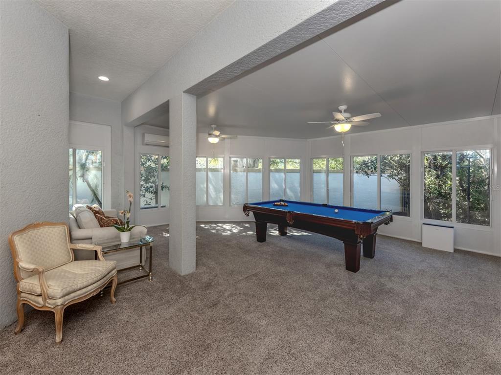 A sunroom features gray carpeting, a pool table, ceiling fans, and a seating area — 111 WAYFOREST DRIVE, VENICE, FL