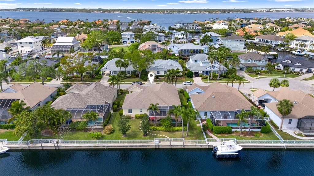 An aerial view shows waterfront houses with swimming pools and boat docks along a canal — 4616 BLUE MARLIN DRIVE, BRADENTON, FL