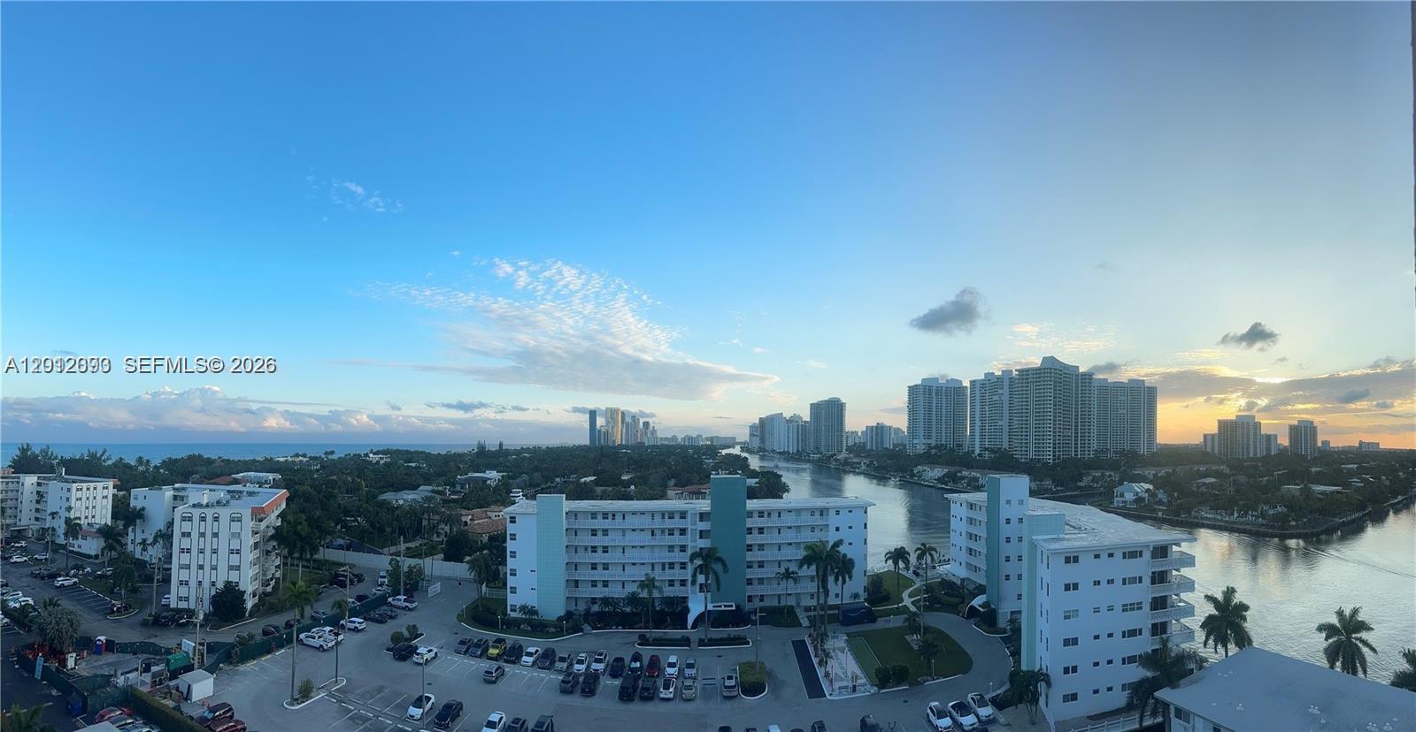 An elevated view shows a waterway, residential buildings, and a parking lot at sunset — 3161 S Ocean Dr # 1107, Hallandale Beach FL 33009, HALLANDALE BEACH, FL
