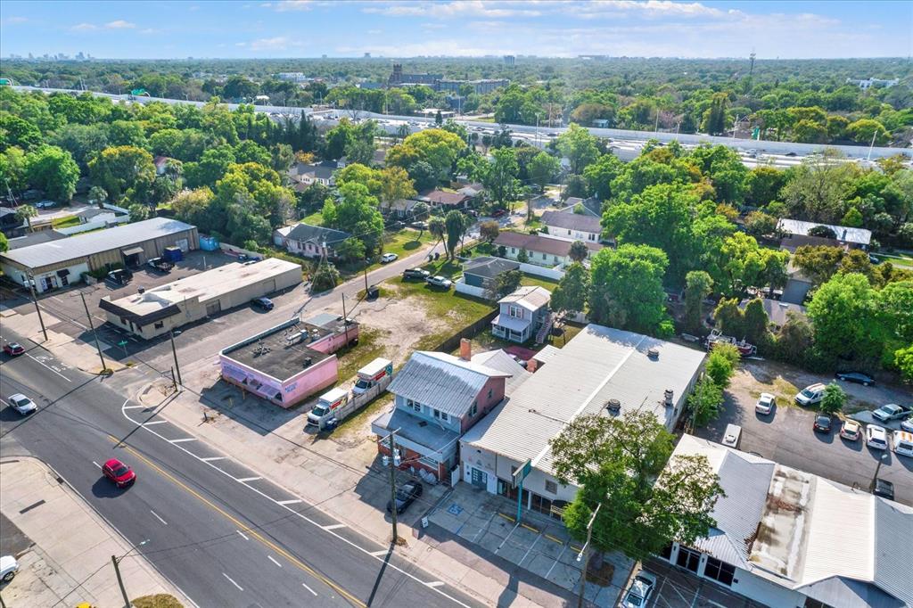 An aerial view shows a commercial street with buildings, parking lots, and surrounding residential trees — 5210 N NEBRASKA AVENUE, TAMPA, FL