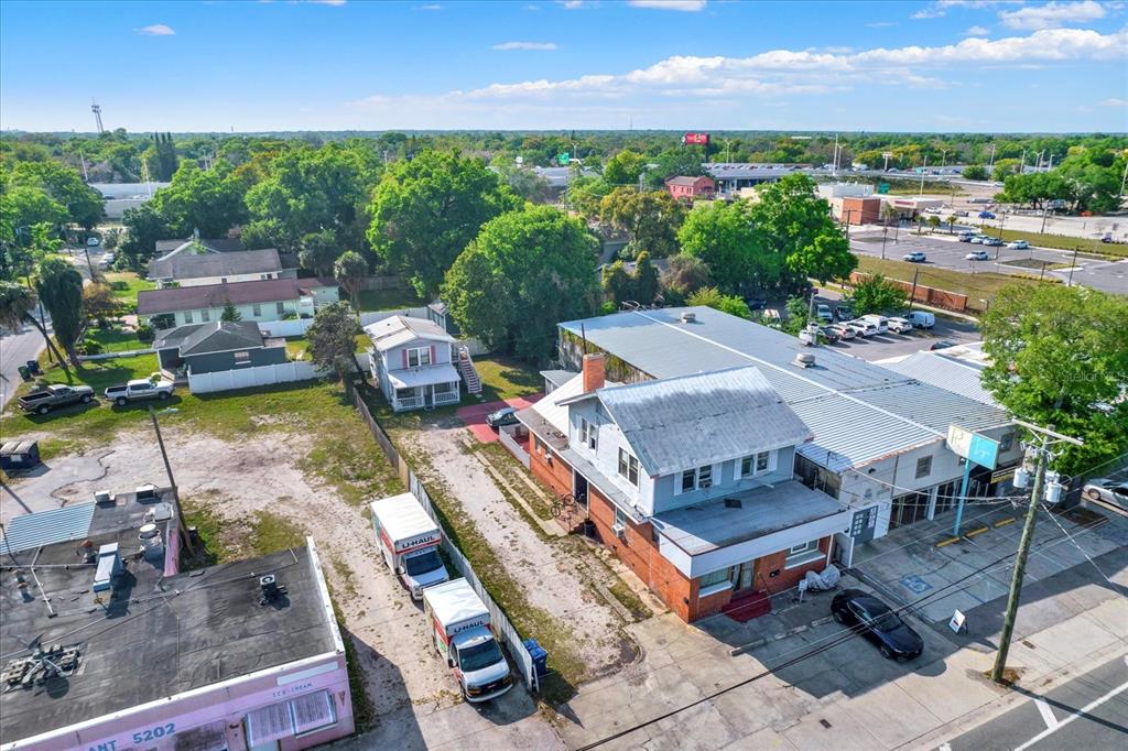 An aerial view shows a multi-story building, a small house, and U-Haul trucks on a lot — 5210 N NEBRASKA AVENUE, TAMPA, FL