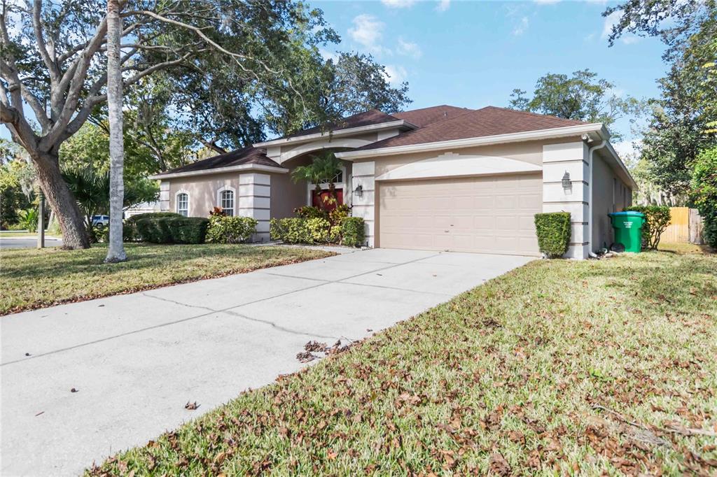 A single-story house with a beige stucco exterior, a two-car garage, and a front walkway — 124 BLUE CREEK DRIVE, WINTER SPRINGS, FL