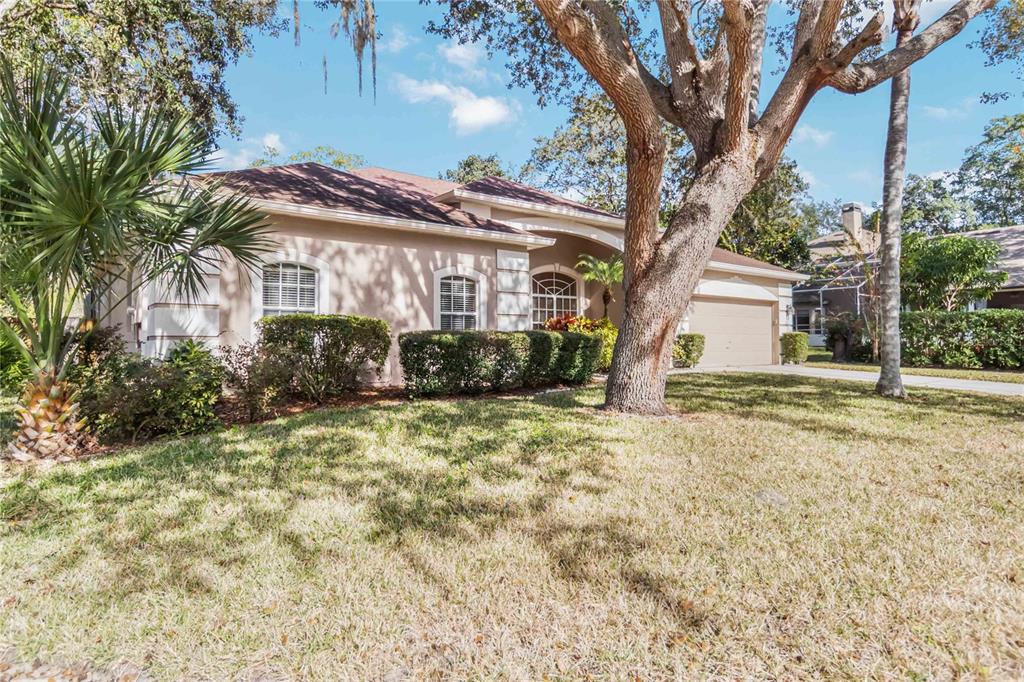A single-story tan house with a teal front door and a two-car garage — 124 BLUE CREEK DRIVE, WINTER SPRINGS, FL