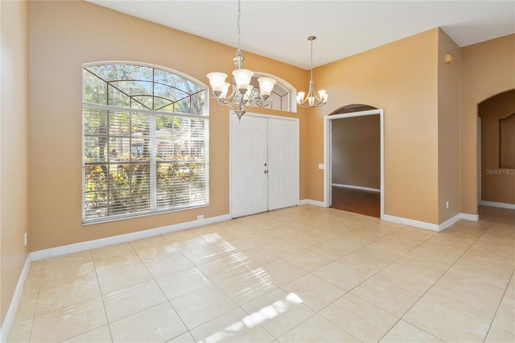 A teal double front door with an arched transom window sits beside a palm tree — 124 BLUE CREEK DRIVE, WINTER SPRINGS, FL