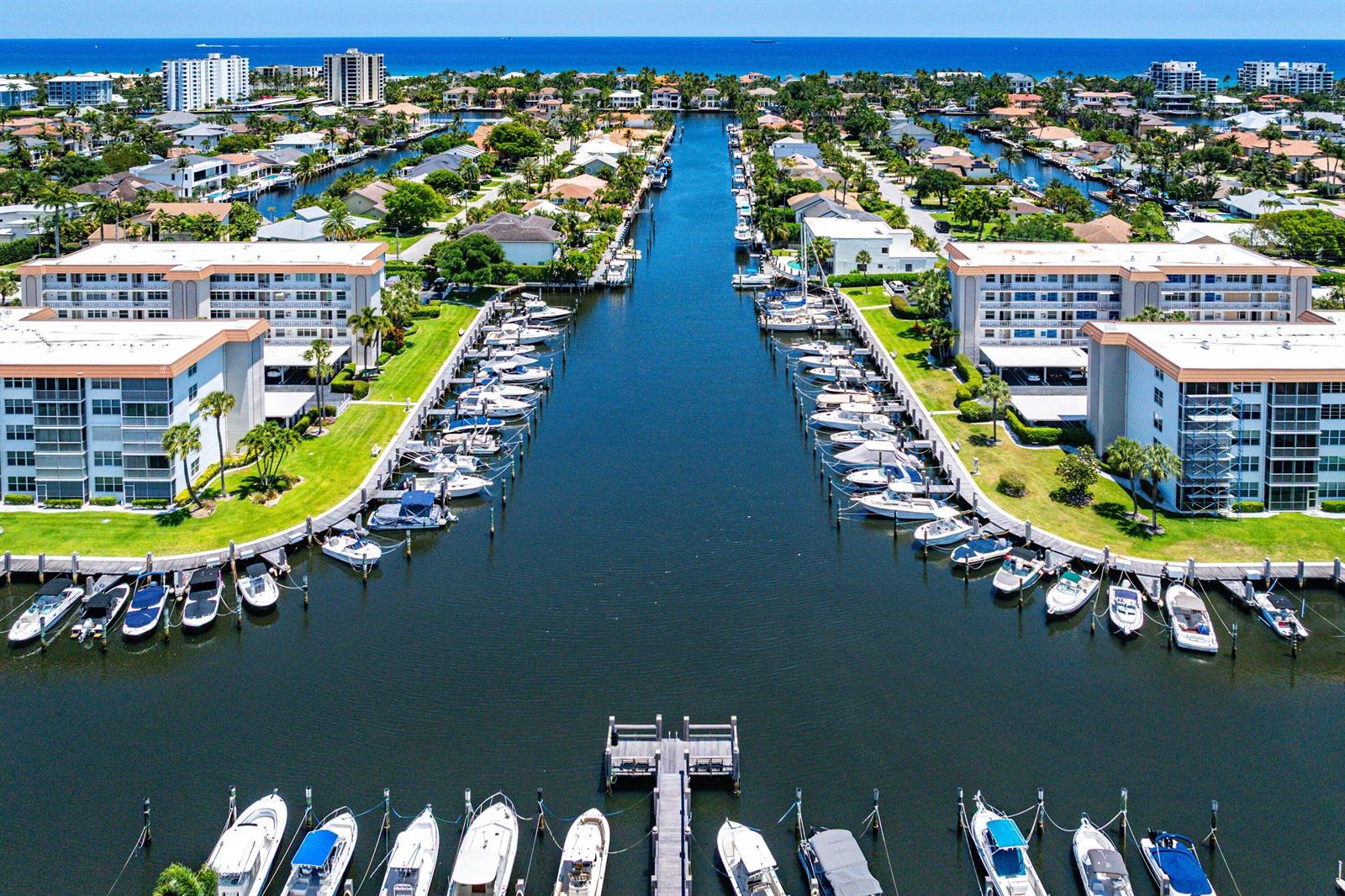 An aerial view shows a canal lined with residential buildings, docks, and numerous docked boats — 2717 Florida Boulevard # 125, Delray Beach FL 33483, DELRAY BEACH, FL