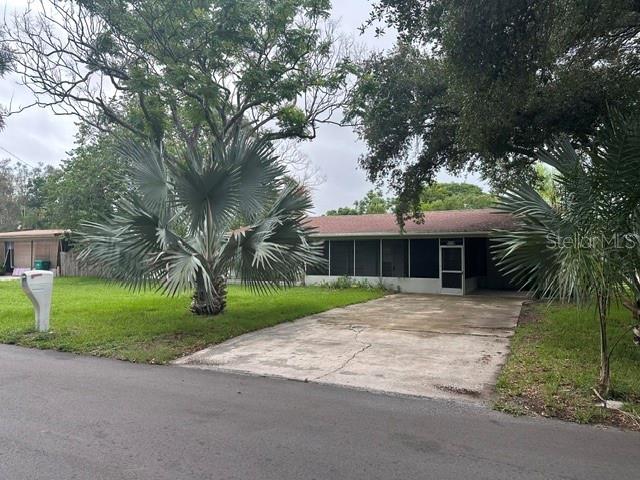 A single-story house with a concrete driveway, a large palm tree, and a screened porch — 2030 HEALY DRIVE, CLEARWATER, FL