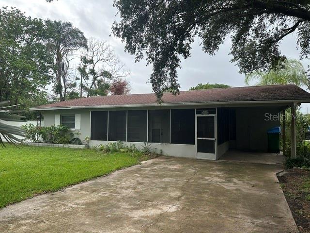A single-story house with a screened-in porch and an attached carport sits on a lot — 2030 HEALY DRIVE, CLEARWATER, FL