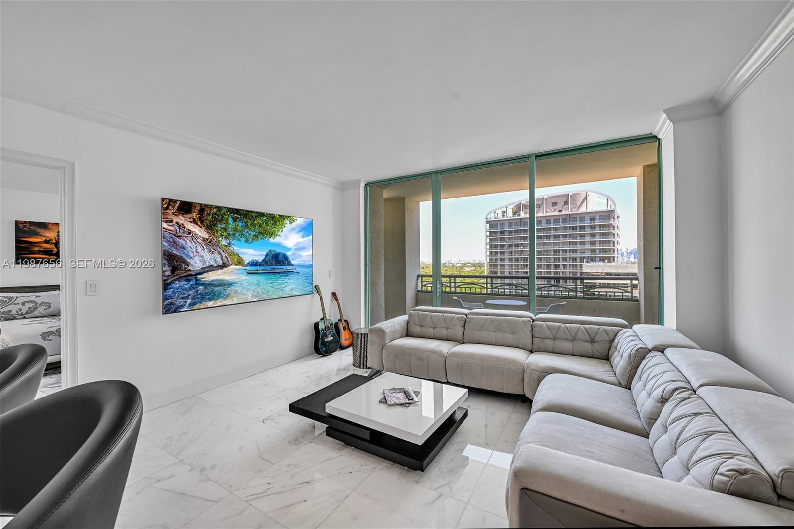 A modern living room features a large sectional sofa, a coffee table, and a wall-mounted television — 3350 SW 27th Ave # 1908, Coconut Grove FL 33133, COCONUT GROVE, FL