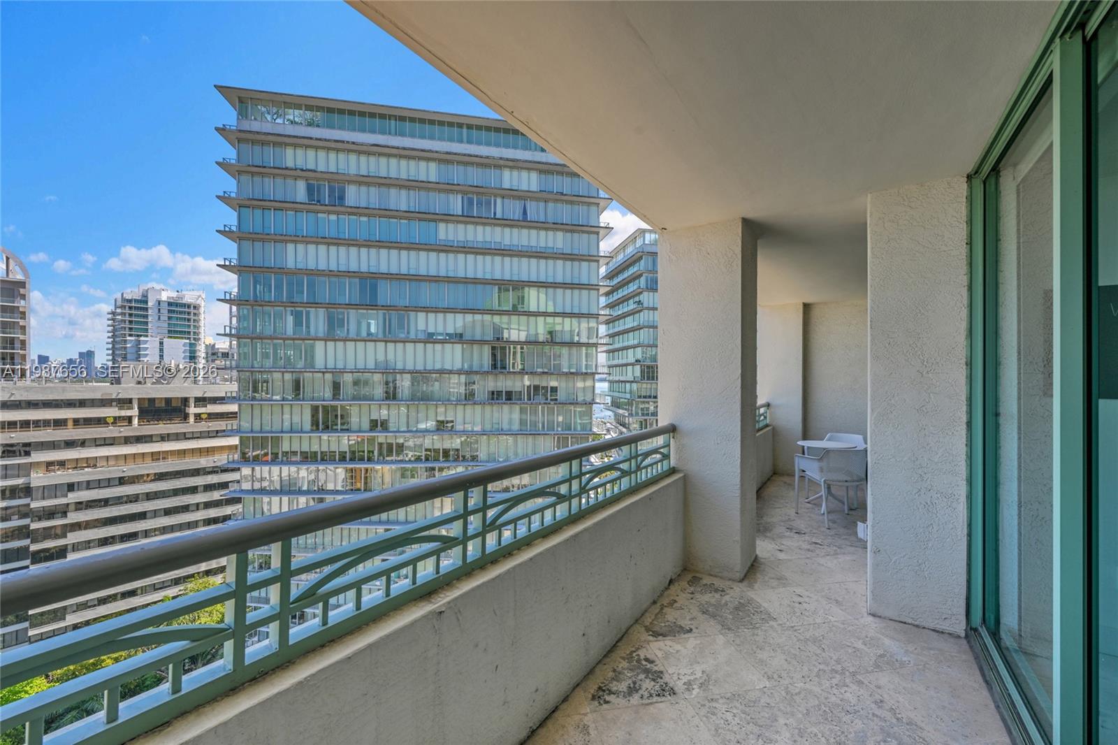 A balcony with stone flooring, a metal railing, and a view of neighboring high-rise buildings — 3350 SW 27th Ave # 1908, Coconut Grove FL 33133, COCONUT GROVE, FL