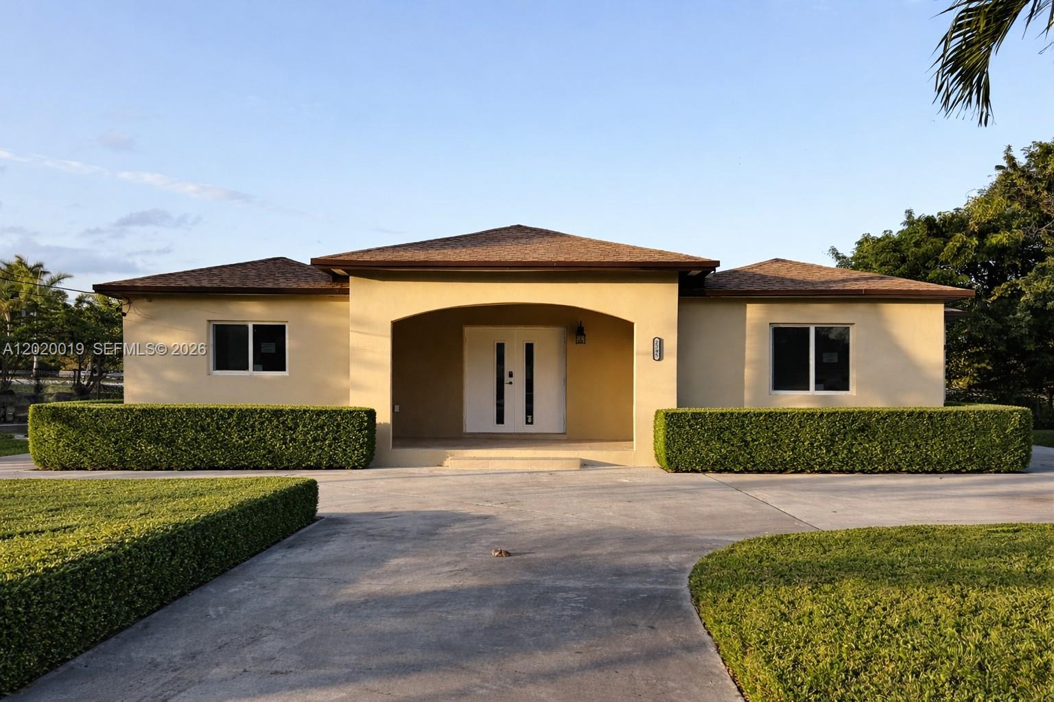 A single-story house with a beige exterior, a recessed entryway, and manicured hedges — 2295 NW 115th St, Miami FL 33167, MIAMI, FL
