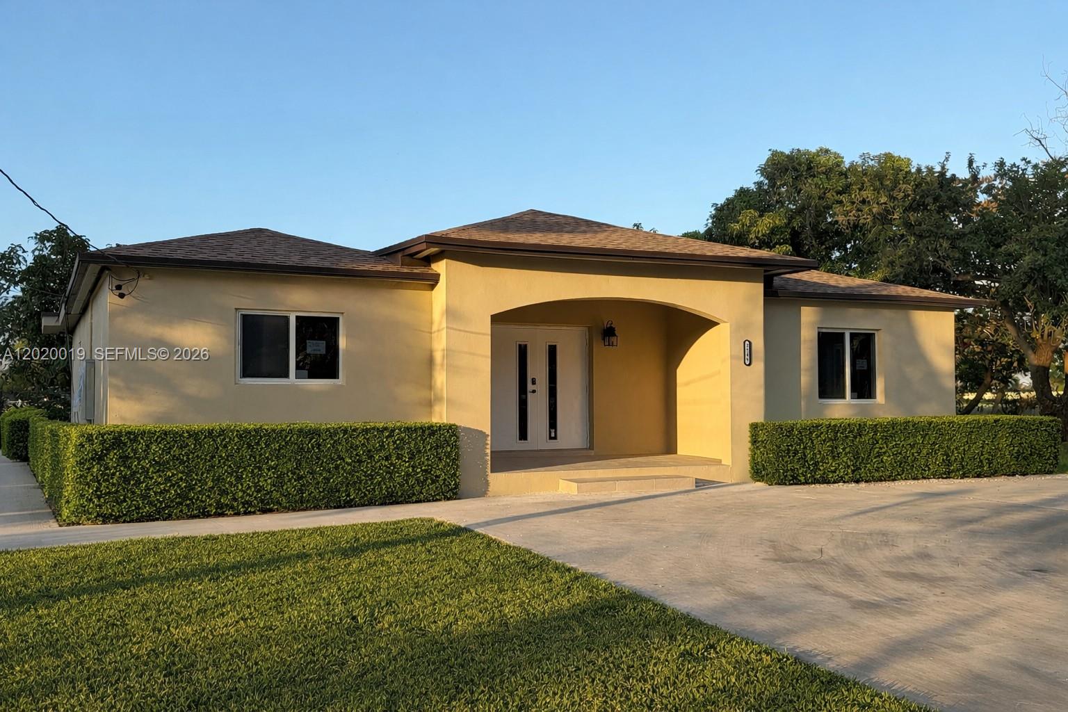 A single-story house with a tan exterior, a recessed entryway, and manicured hedges — 2295 NW 115th St, Miami FL 33167, MIAMI, FL
