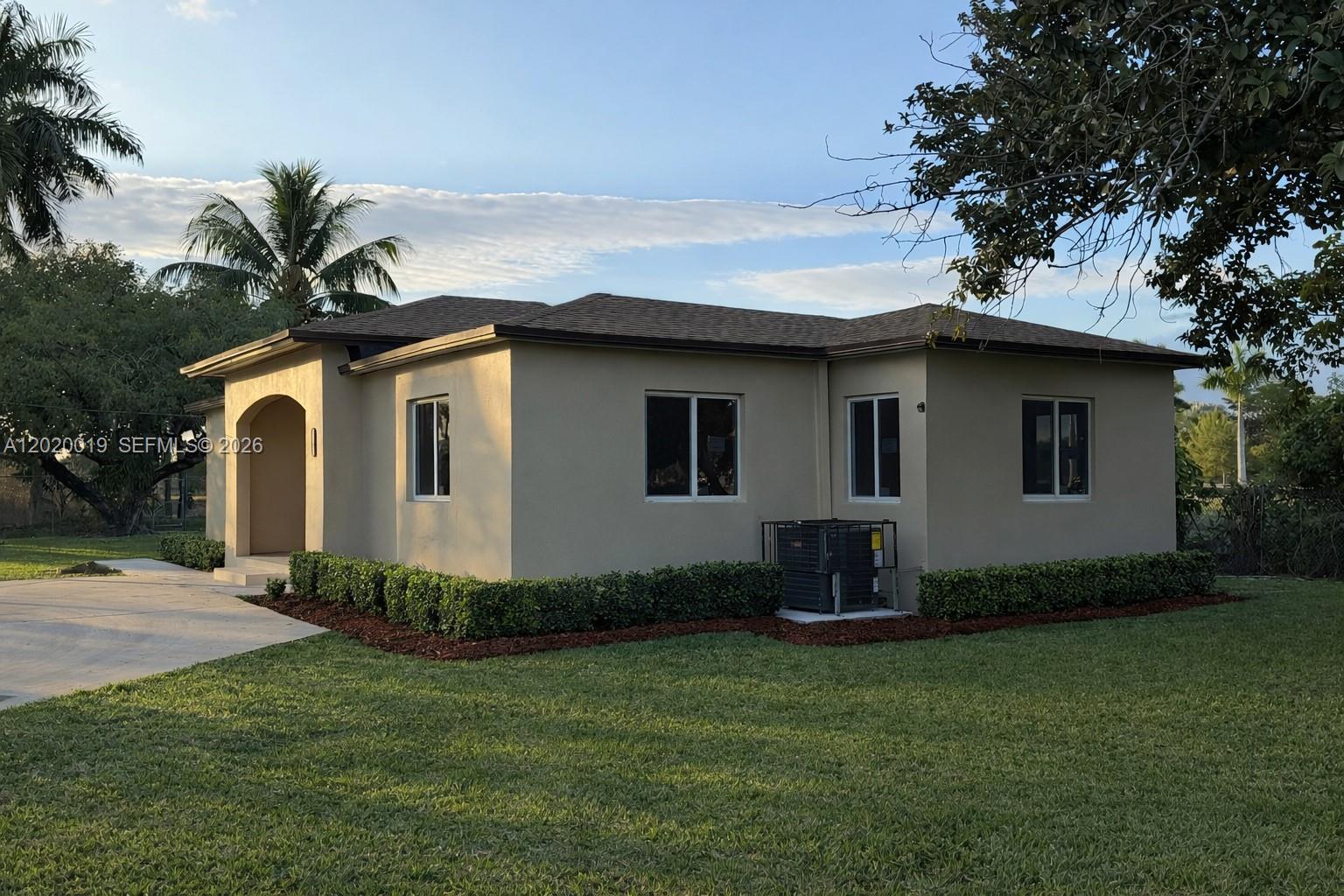 A single-story beige house with a dark roof, arched entryway, and manicured hedges — 2295 NW 115th St, Miami FL 33167, MIAMI, FL