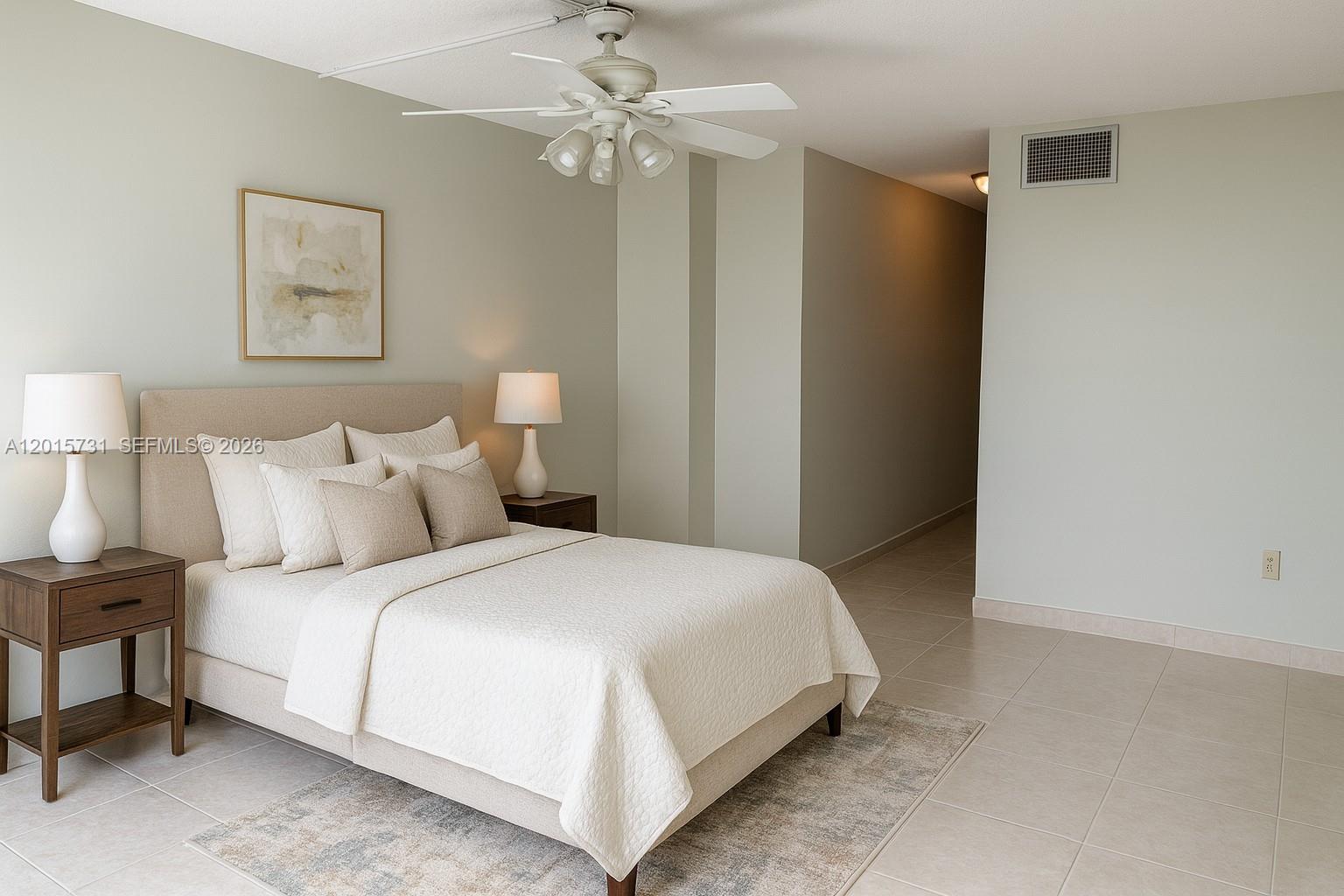 A bedroom features a bed with neutral bedding, two nightstands with lamps, and tile flooring — 1750 NE 191st St # 3, Miami FL 33179, MIAMI, FL