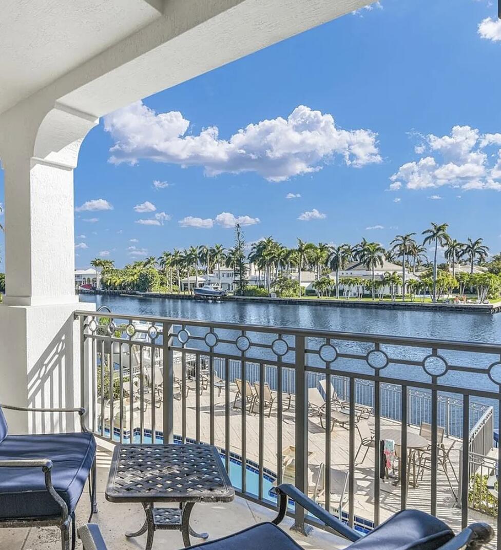 A balcony with outdoor furniture overlooks a canal lined with palm trees and houses — 3042 WATERSIDE Circle, Boynton Beach FL 33435, BOYNTON BEACH, FL