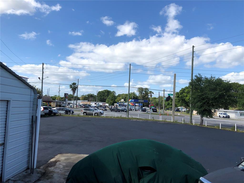 An outdoor view of a paved parking lot facing a road with a gas station — 6180 HAINES ROAD N, ST PETERSBURG, FL