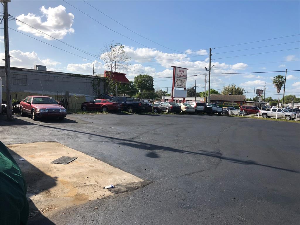 A paved parking lot with several parked cars sits in front of a commercial building — 6180 HAINES ROAD N, ST PETERSBURG, FL